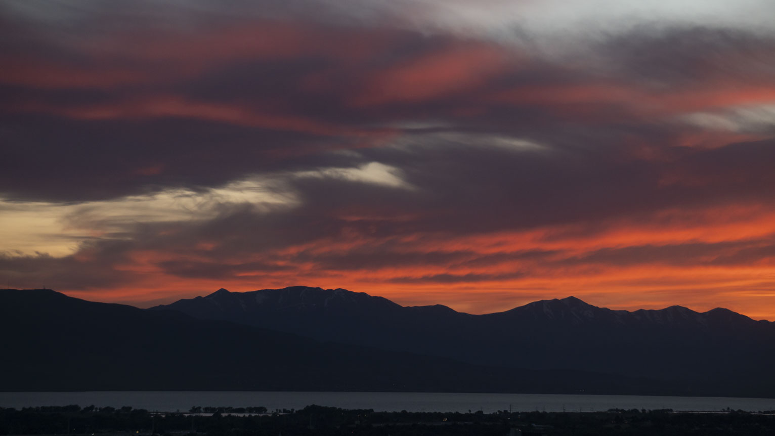 The sunset over dark purple cast mountains